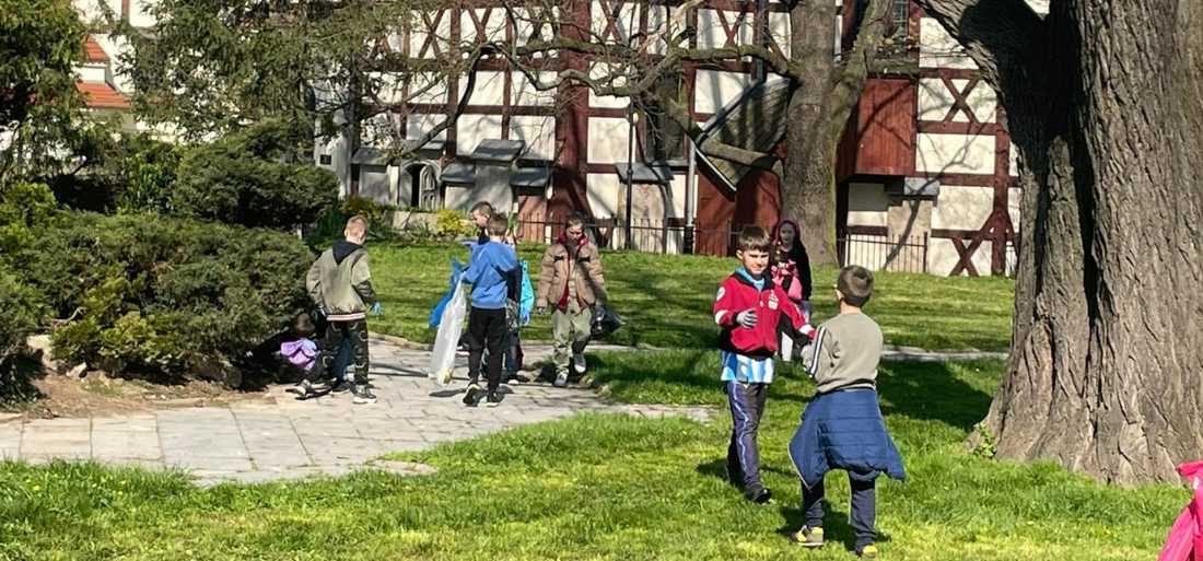 Zdjęcie przedstawiające sprzątających uczniów
